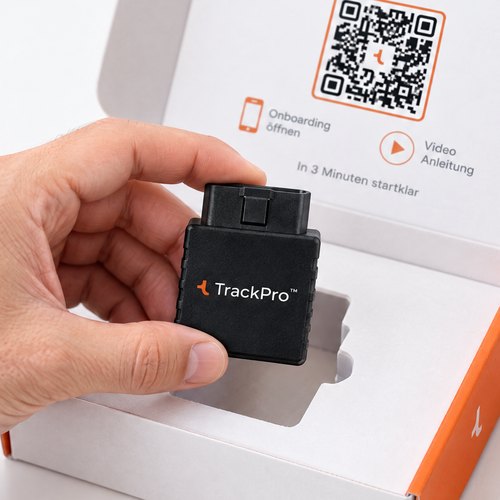Hand nimmt den TrackPro Stecker aus dem geöffneten Paket mit Startkarte und QR-Code